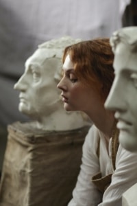young woman next to statues looking sad, representative of dissociative identity disorder