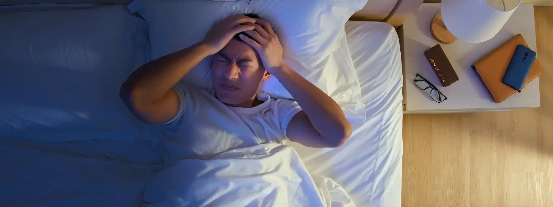 Man lying in bed with hands on head, struggling with anxiety and insomnia – nighttime mental health challenges treated at Alter Behavioral Health