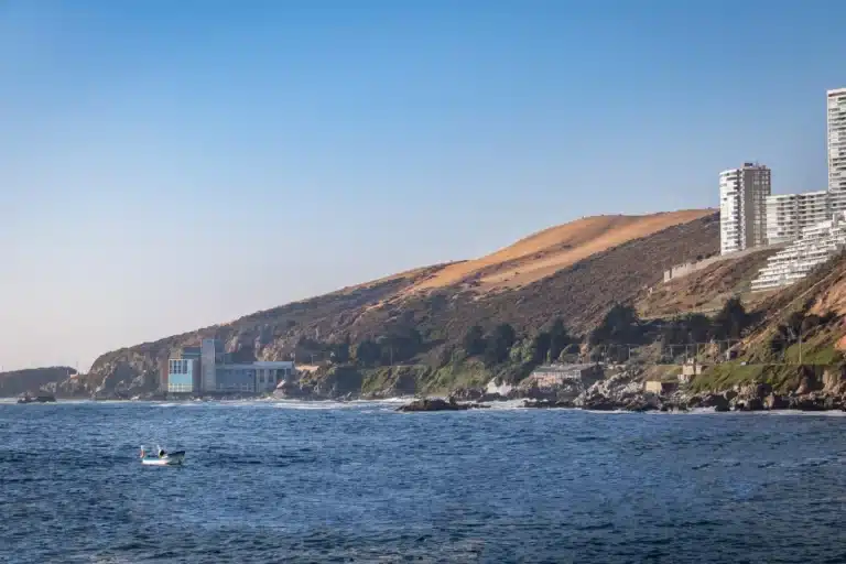 A scenic view of Del Mar, California, featuring coastal cliffs, sandy beaches, and ocean waves under a clear blue sky.