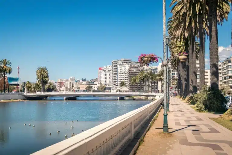 A scenic view of Del Mar, California, featuring coastal cliffs, sandy beaches, and ocean waves under a clear blue sky.