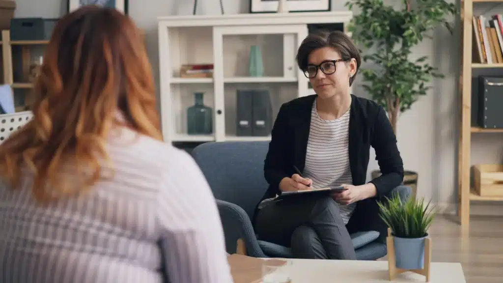 Therapist leading a counseling session for women discussing mental health, empowerment, and recovery in a supportive environment focused on women-only therapy programs