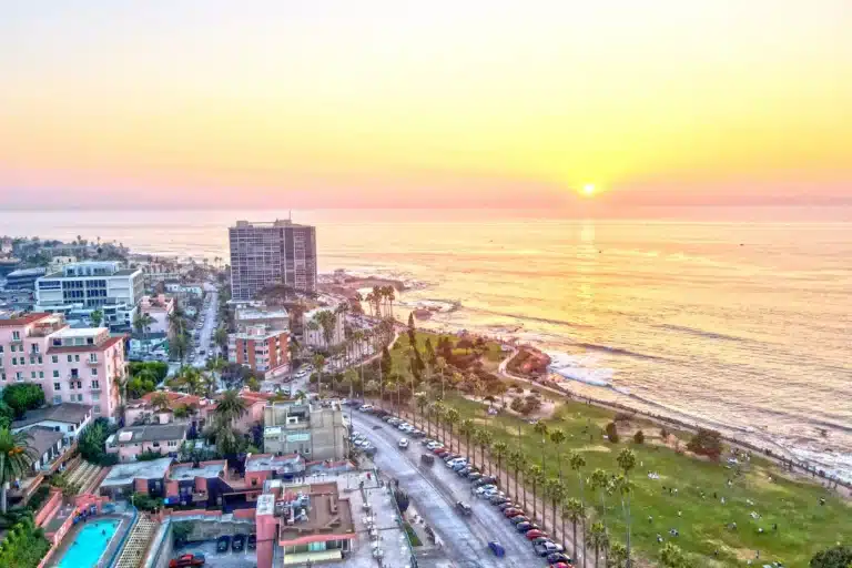 Coastal view of La Jolla, California with rugged cliffs, blue ocean waves, and bright sky showcasing the scenic seaside landscape.