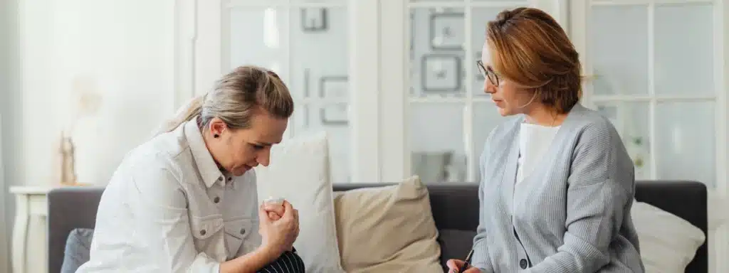 Person meeting therapist in office with text about Optum Behavioral Health insurance coverage.