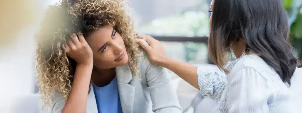 Patient discussing anxiety and recovery options with counselor in supportive clinical setting.