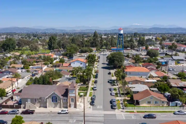 Aerial view of Placentia, California, featuring residential neighborhoods, tree-lined streets, and local businesses under a clear Southern California sky.