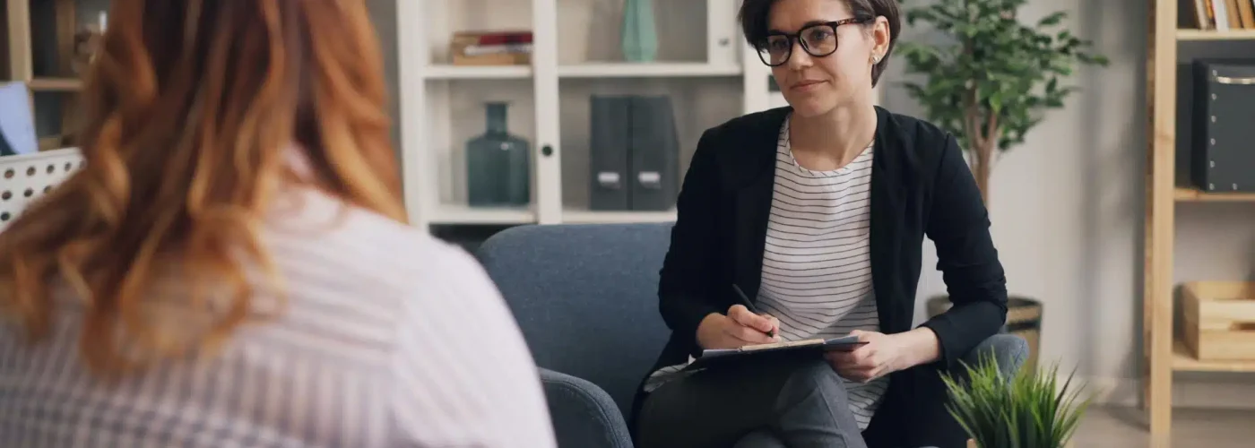 Therapist leading a counseling session for women discussing mental health, empowerment, and recovery in a supportive environment focused on women-only therapy programs
