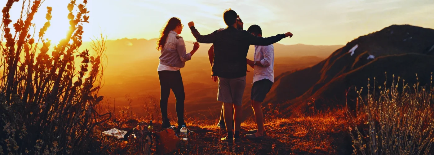 Friends at sunset on a mountain ridge celebrating recovery and support, symbolizing hope after quitting Xanax.