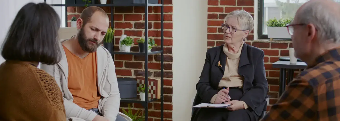 Person discussing emotional struggles with a therapist during a mental health treatment consultation